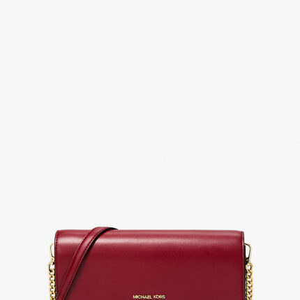 Bolso bandolera mediana Michael Kors color cereza con correa cruzada.